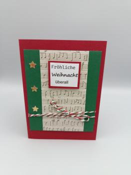 Handgemachte Weihnachtskarte mit Musikstreifen und Sternen – „Fröhliche Weihnacht überall“